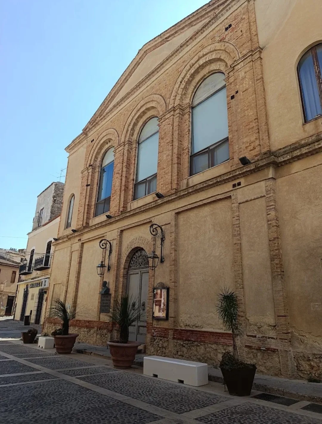 La facciata del Teatro Regina Margherita a Racalmuto, con i finestroni ad arco e il portone d'ingresso
